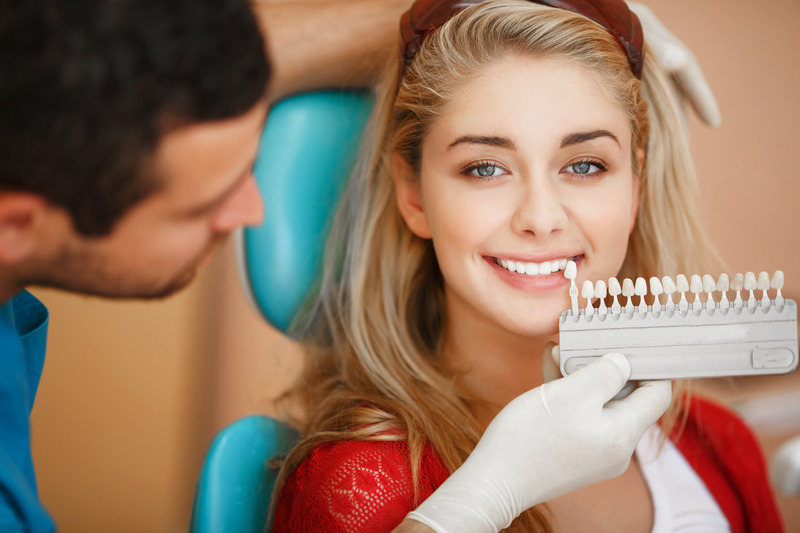 Patient smiling in a mirror after cosmetic dentistry